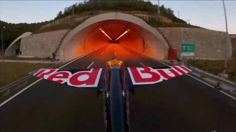 Stunt pilot flies through two tunnel tubes at 245 km/h just under a meter above the ground